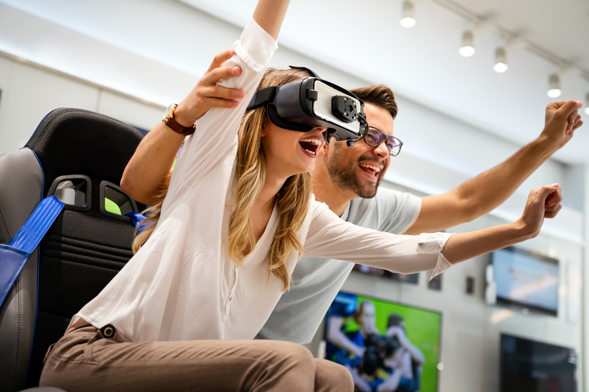 Excited couple experiencing virtual reality in-store with premium gear, highlighting immersive tech and gaming accessories on sale. 