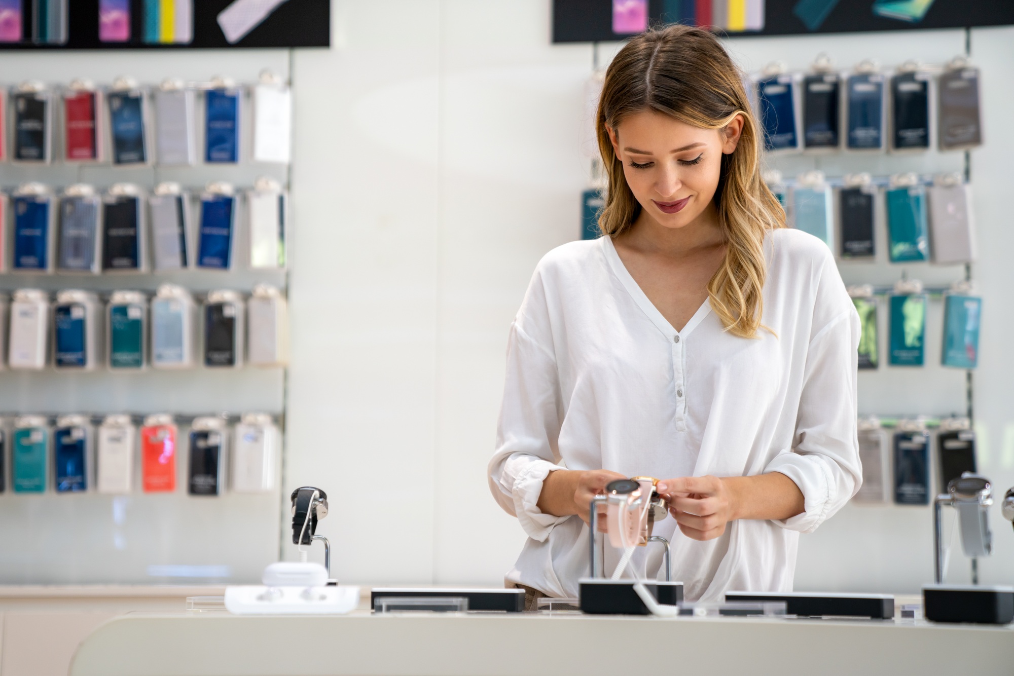 Customer examining a smartwatch in a retail tech store, highlighting seamless tech product returns Florida shoppers can rely on for worry-free shopping.

