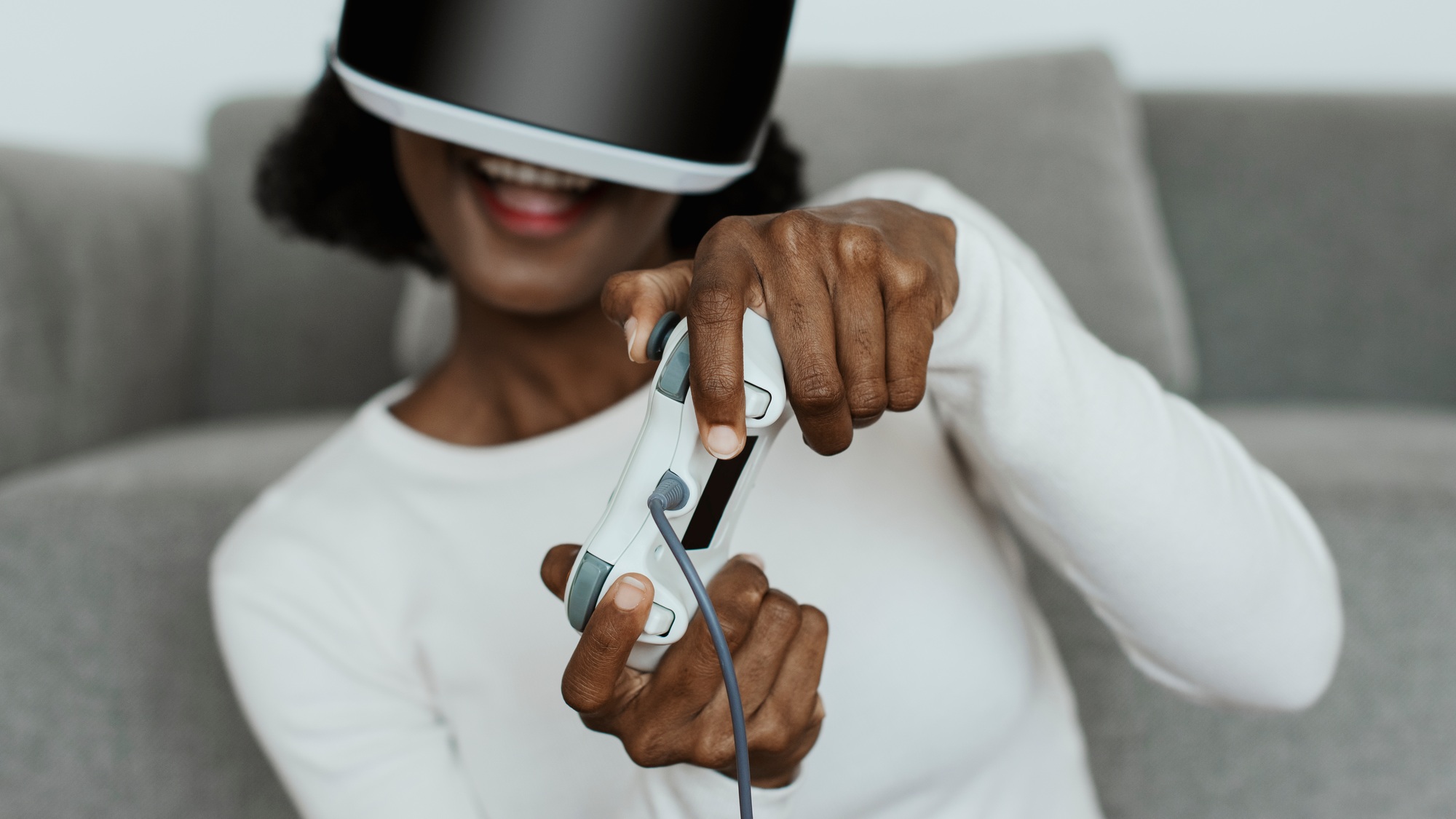 Enthusiastic gamer immersed in gameplay using PlayStation VR gear and a wireless controller at home, showcasing next-gen virtual reality entertainment.
