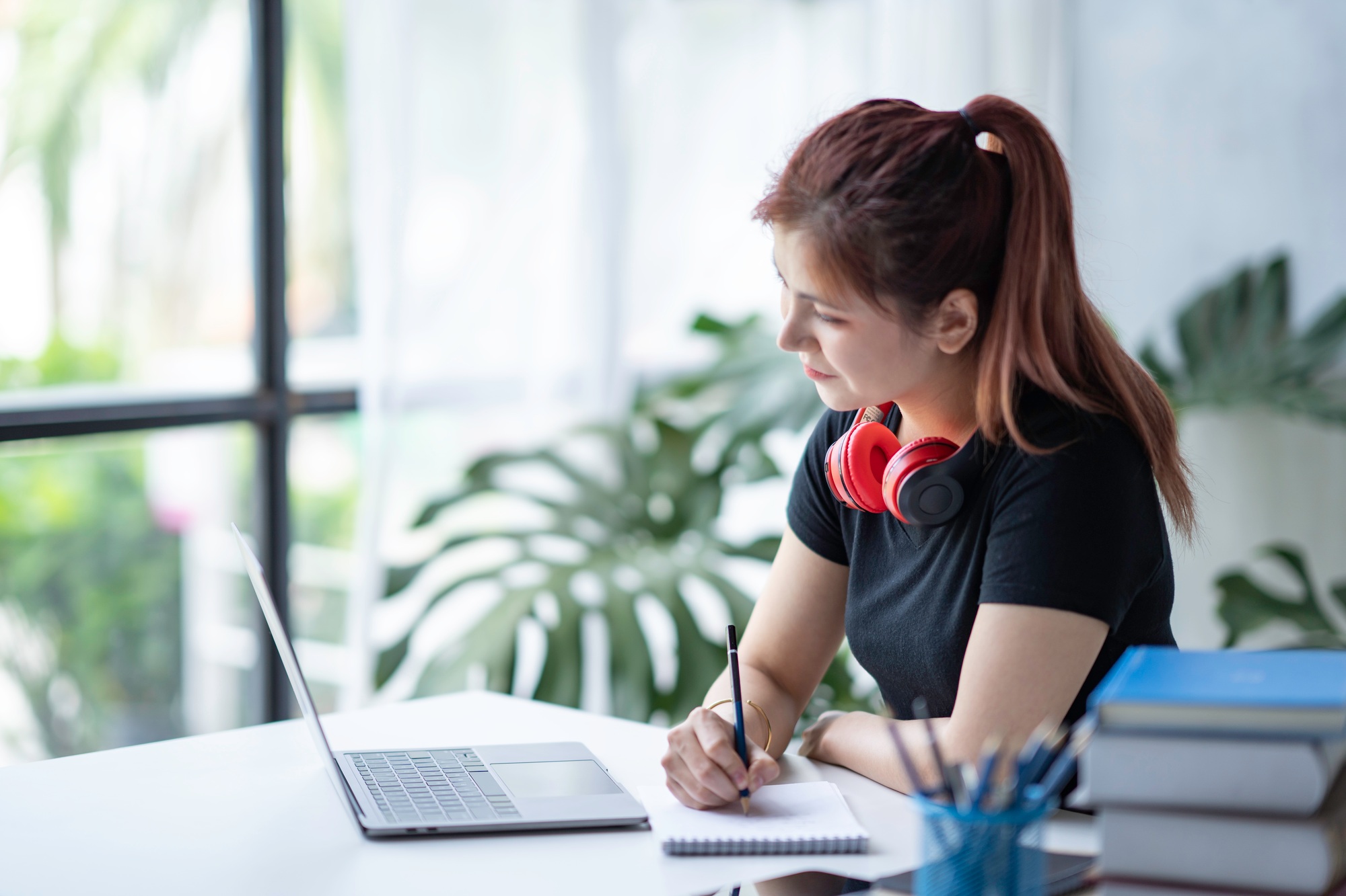 Focused young professional using one of the latest creative workstation laptops for design and planning tasks in a modern workspace with natural light.