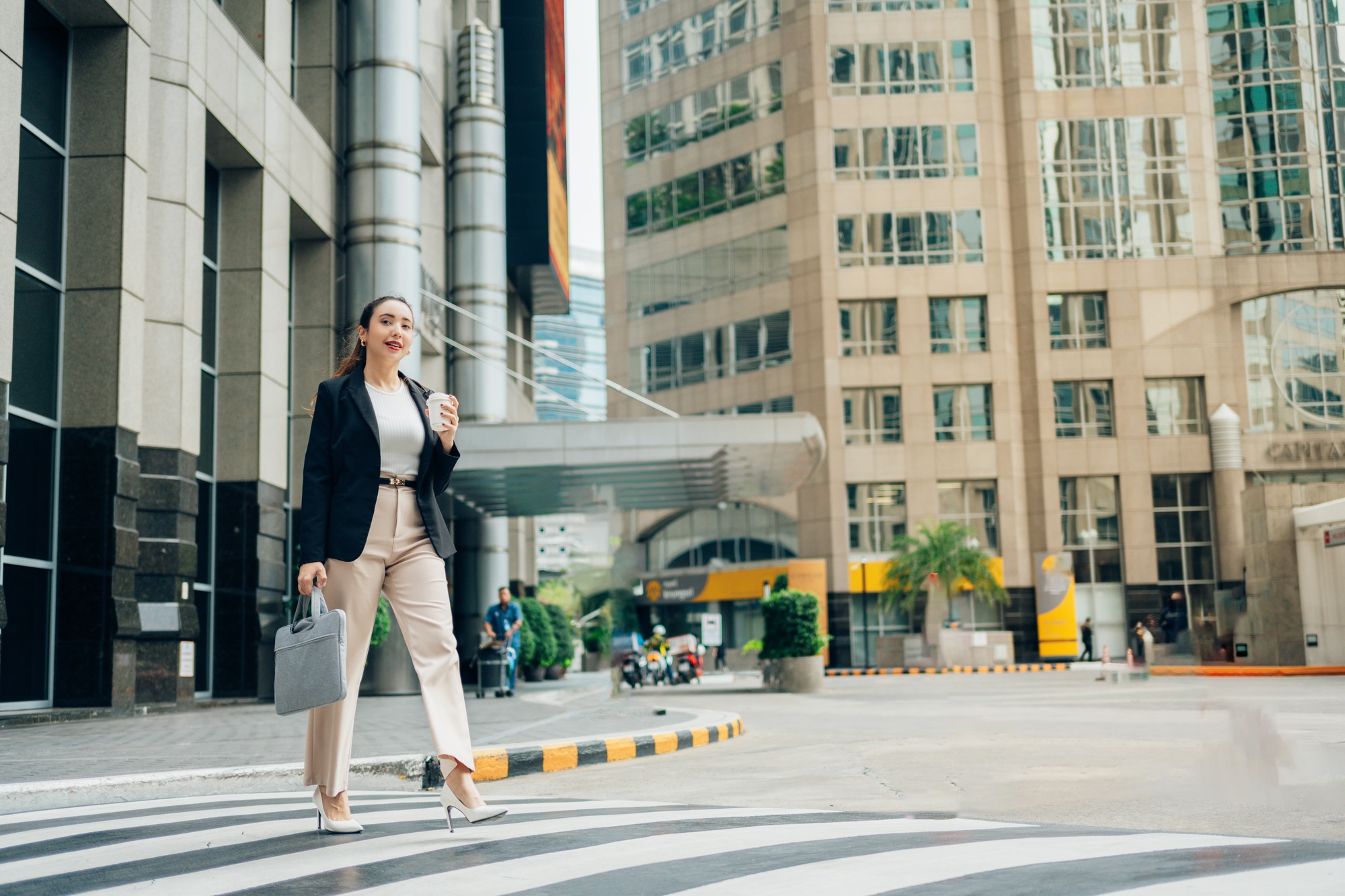 Confident businesswoman crossing a city street with a stylish laptop bag in hand—ideal for promoting professional gear with the call to Buy Laptop Bags and Stands.