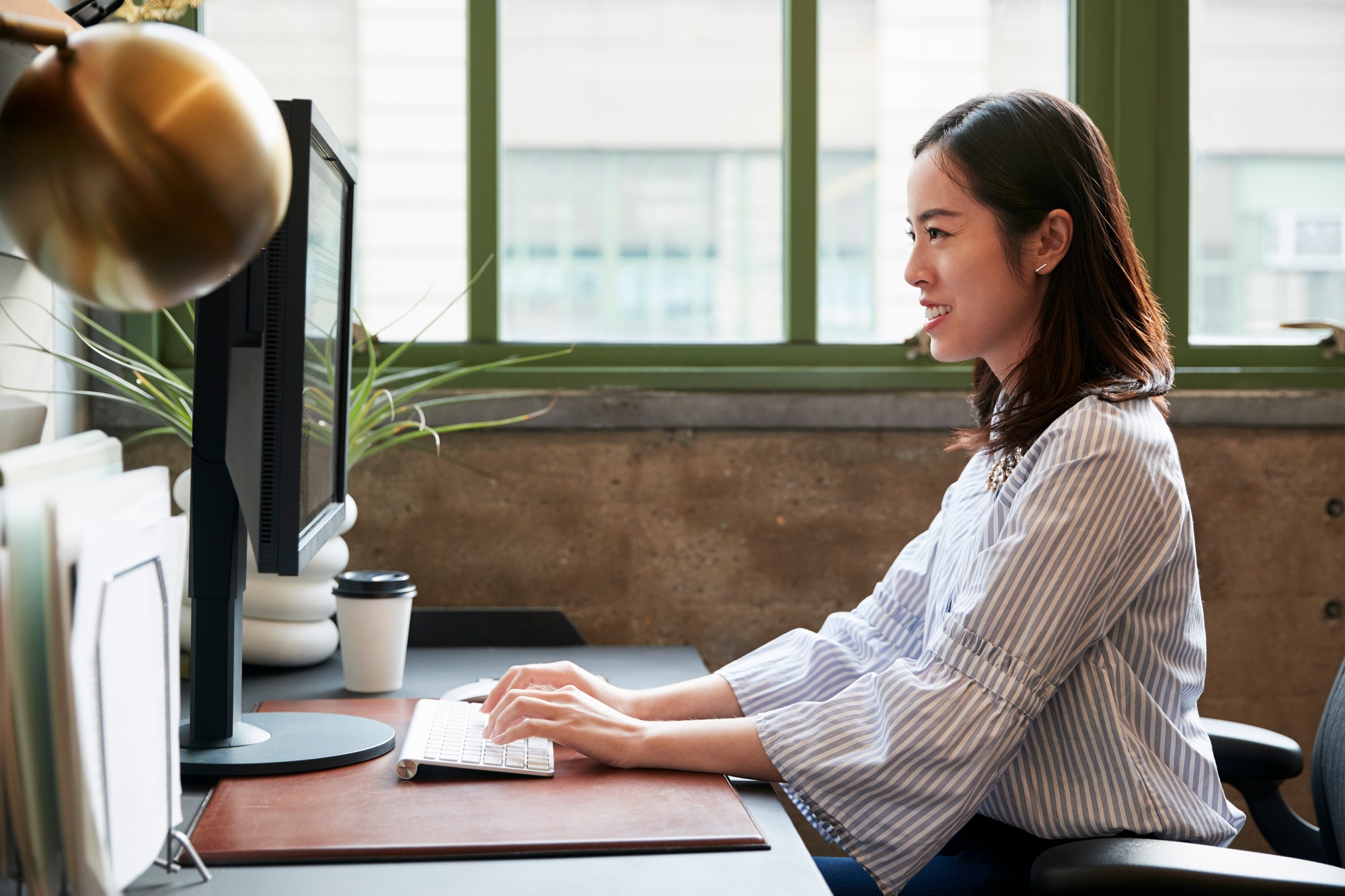 Professional woman working on a desktop setup in a modern office environment—ideal visual representation for a Computer Components Store marketing high-performance gear.