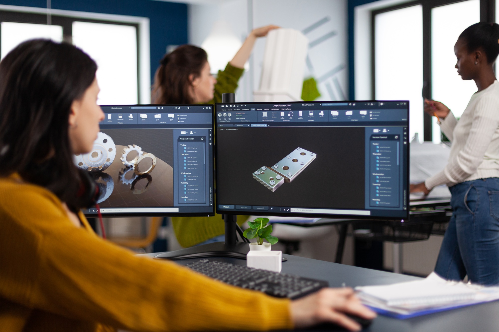 Engineers using 3D modeling software on dual monitors in a modern office, showcasing high-performance setups—ideal for professionals who buy graphics cards online.