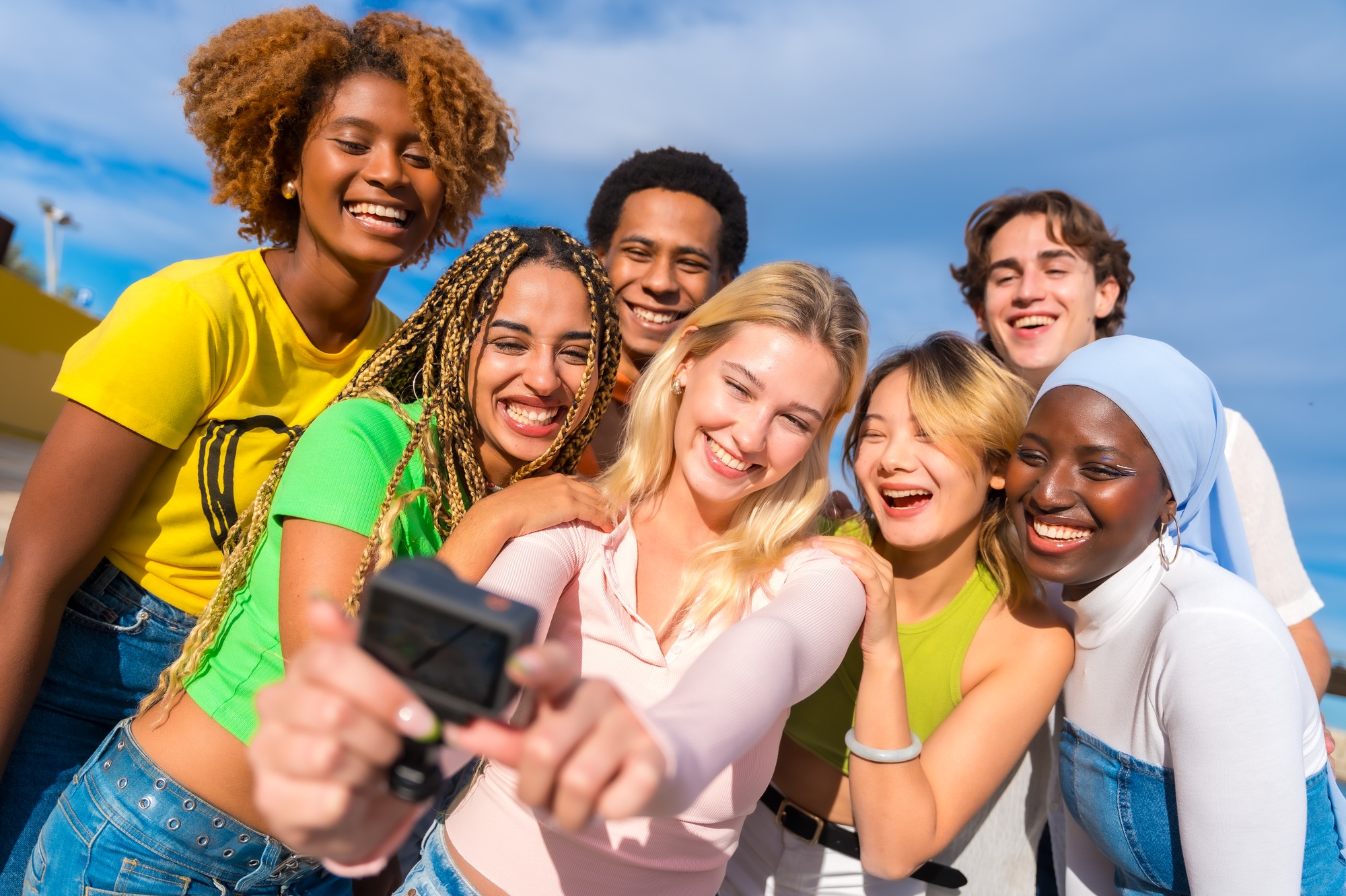 Group of young adults capturing a vibrant moment outdoors using GoPro cameras accessories—showcasing lifestyle gear perfect for social content and adventure.

