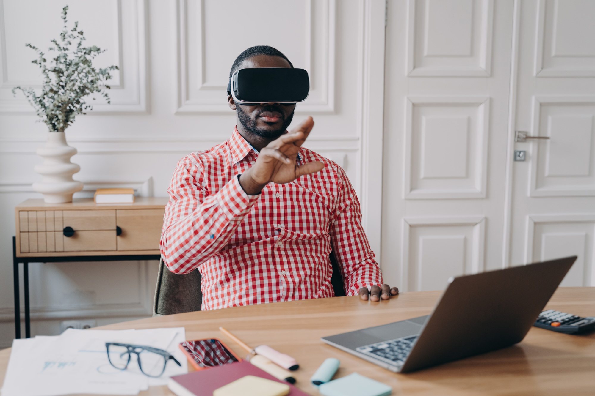 Professional using VR headset with a high-performance laptop in a modern office—showcasing power and immersion from top gaming laptops for sale Florida. 