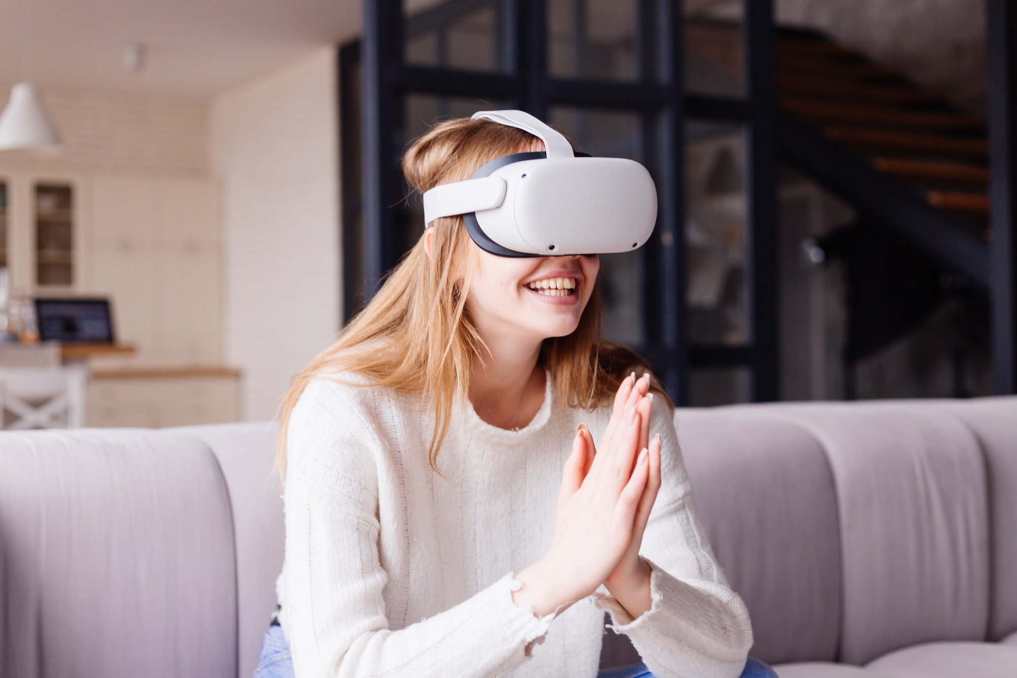 Smiling woman enjoying immersive gameplay with a VR headset at home—capturing the excitement of next-gen entertainment powered by VR Controllers for Sale.